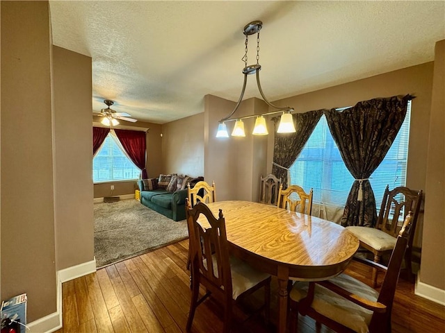 718 Oakland Ave, Kansas City, KS 66101 - dining room with ceiling fan, a textured ceiling, baseboards, and hardwood / wood-style floors