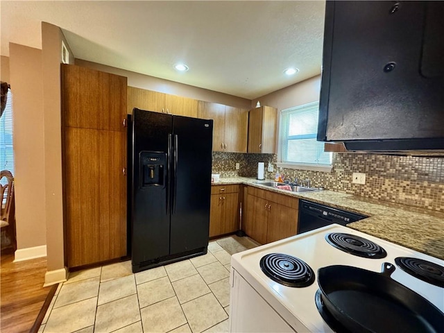 718 Oakland Ave, Kansas City, KS 66101 - kitchen with decorative backsplash, brown cabinetry, light countertops, black appliances, and a sink