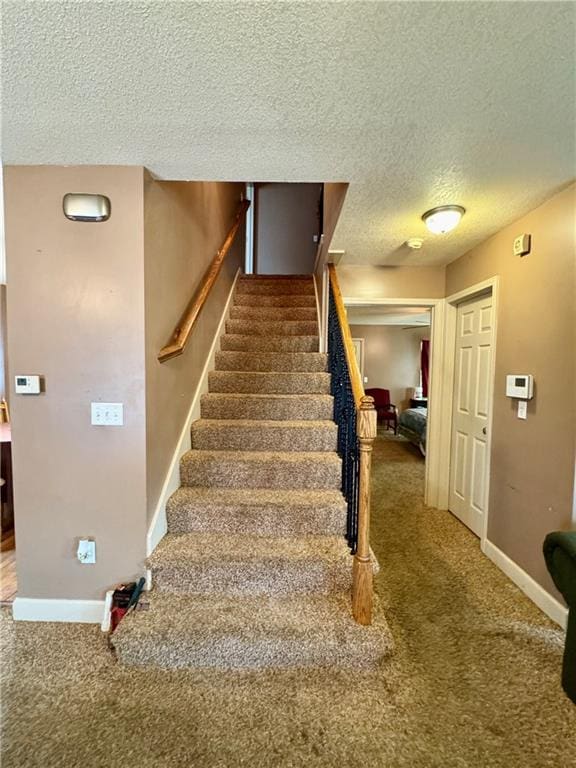 718 Oakland Ave, Kansas City, KS 66101 - staircase with carpet floors, baseboards, and a textured ceiling