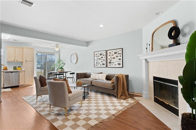 living room featuring a fireplace, recessed lighting, visible vents, light wood-style floors, and baseboards