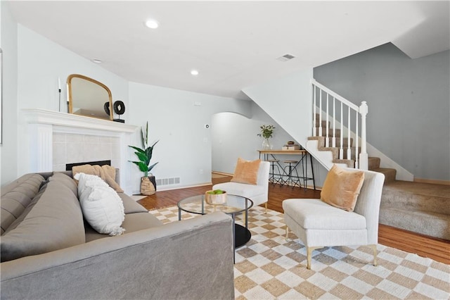 living room featuring visible vents, stairway, and light wood-style flooring