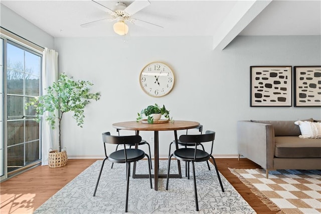 dining area featuring light wood-style floors, baseboards, and a ceiling fan