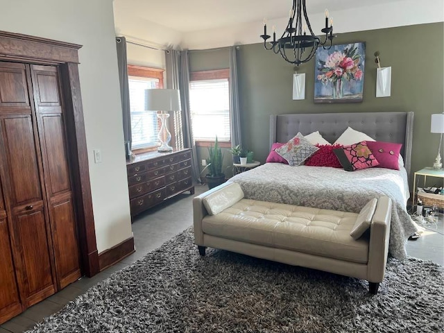 bedroom with an inviting chandelier and baseboards