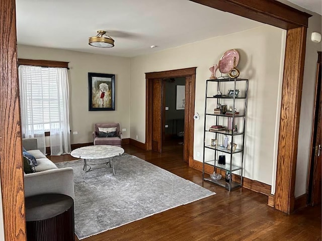 sitting room featuring baseboards and dark wood-type flooring