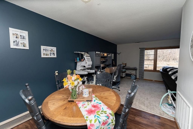 dining space with baseboards, visible vents, lofted ceiling, wood finished floors, and a textured ceiling