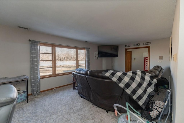 carpeted living area featuring visible vents and baseboards