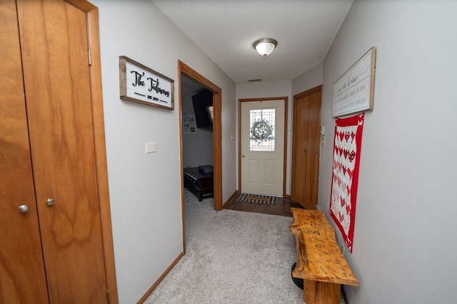 doorway to outside featuring carpet floors and baseboards