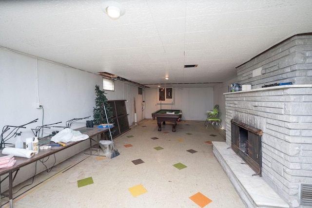 unfurnished living room featuring a brick fireplace, pool table, and tile patterned floors