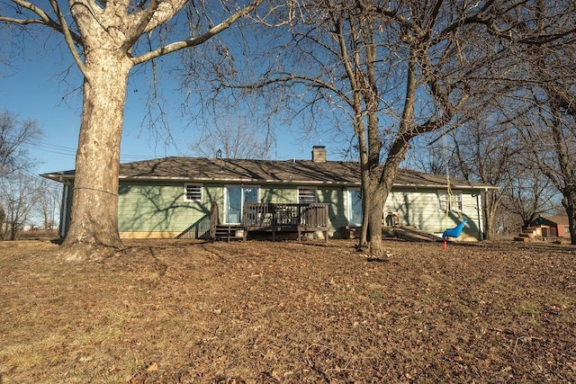 back of house with a deck and a chimney