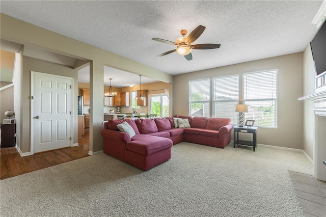 1716 NW 54th Ter, Kansas City, MO 64118 - living room with light carpet, a ceiling fan, baseboards, a textured ceiling, and a chandelier