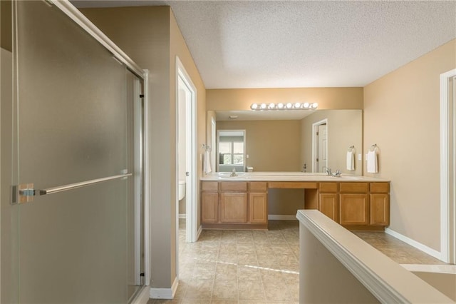 1716 NW 54th Ter, Kansas City, MO 64118 - bathroom featuring a shower stall, double vanity, a textured ceiling, baseboards, and toilet