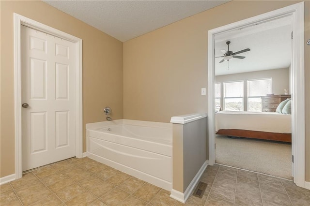 1716 NW 54th Ter, Kansas City, MO 64118 - ensuite bathroom featuring a bath, baseboards, a ceiling fan, and a textured ceiling
