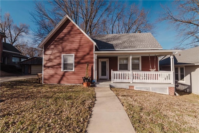 view of front facade with a porch, a shingled roof, and a front yard