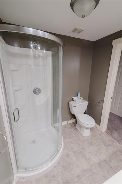 bathroom featuring a stall shower, baseboards, visible vents, and toilet