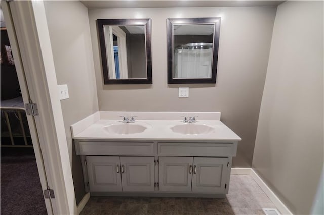 bathroom featuring double vanity, a sink, and baseboards