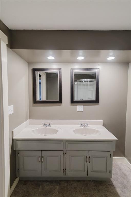 full bathroom with a sink, baseboards, and double vanity