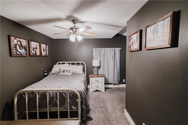 carpeted bedroom with a textured ceiling, ceiling fan, and baseboards