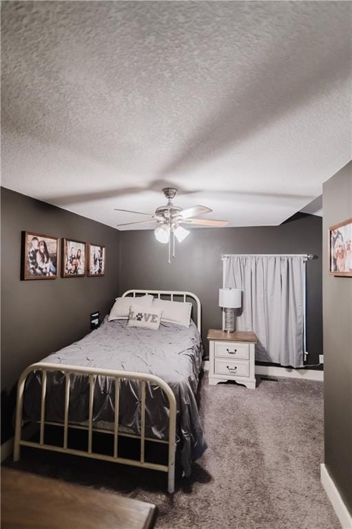 carpeted bedroom featuring a ceiling fan and a textured ceiling