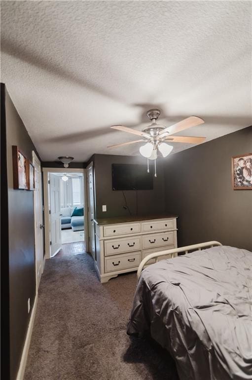 bedroom featuring a textured ceiling, dark colored carpet, ceiling fan, and baseboards