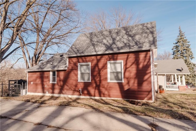 view of side of property with roof with shingles