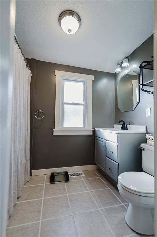 full bathroom featuring visible vents, toilet, vanity, tile patterned flooring, and baseboards