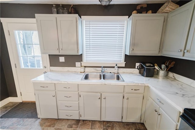 kitchen featuring white cabinets and a sink