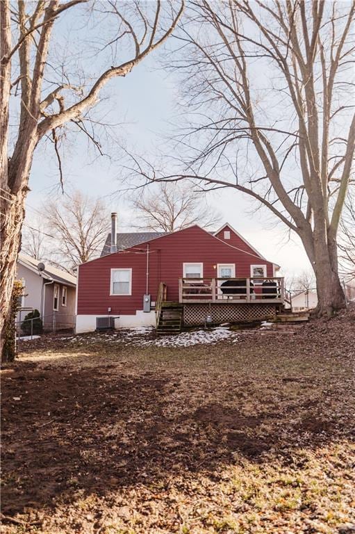 rear view of property with central AC, a chimney, and a wooden deck