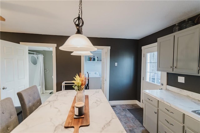 dining room featuring washer / dryer and baseboards