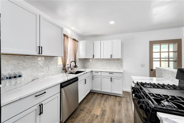 kitchen with stainless steel dishwasher, black range with gas stovetop, a sink, and white cabinets