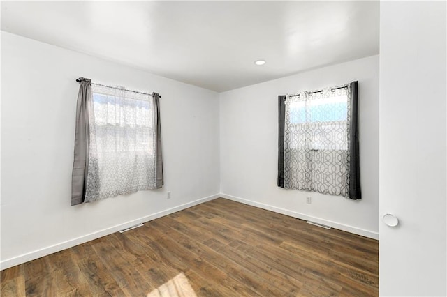 spare room featuring baseboards, dark wood-type flooring, and recessed lighting