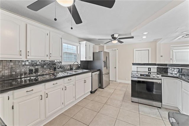 kitchen featuring stainless steel appliances, dark countertops, and a sink