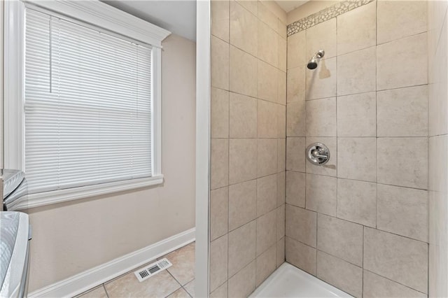 full bath featuring tile patterned flooring, baseboards, visible vents, and tiled shower