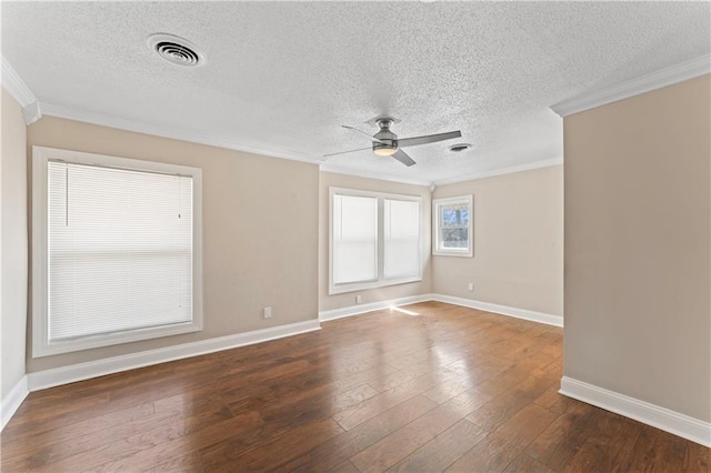 empty room with ornamental molding, visible vents, and dark wood finished floors