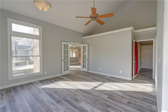 empty room with baseboards, french doors, wood finished floors, high vaulted ceiling, and a ceiling fan