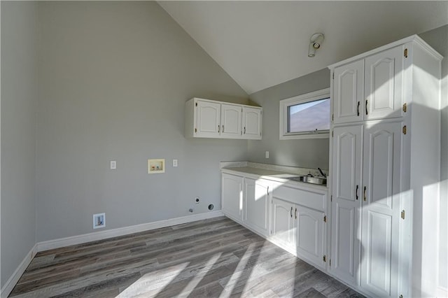 laundry room featuring washer hookup, wood finished floors, cabinet space, baseboards, and gas dryer hookup