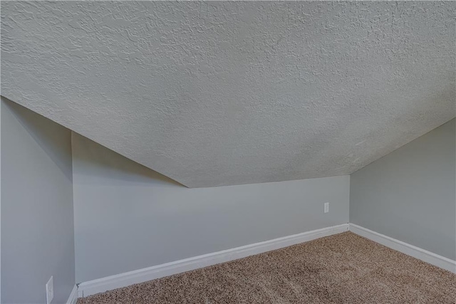 bonus room with carpet flooring, a textured ceiling, baseboards, and vaulted ceiling