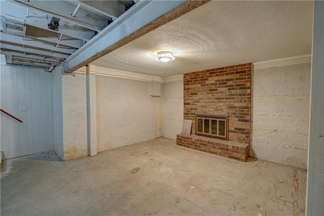 below grade area with a brick fireplace and a textured ceiling