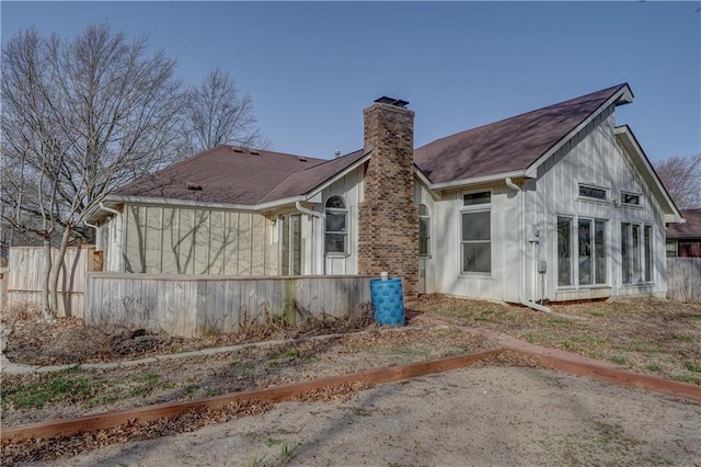 back of property with fence and a chimney