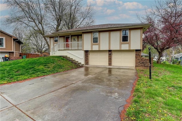 view of front of property featuring brick siding, concrete driveway, stairway, a front lawn, and stucco siding