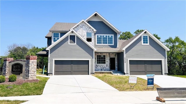 view of front of property with driveway, stone siding, and a garage