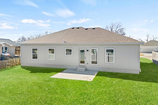 back of property with a shingled roof, a lawn, fence, and a patio