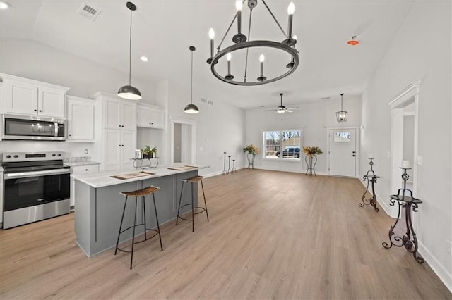 kitchen with white cabinetry, visible vents, stainless steel appliances, and light wood-style flooring