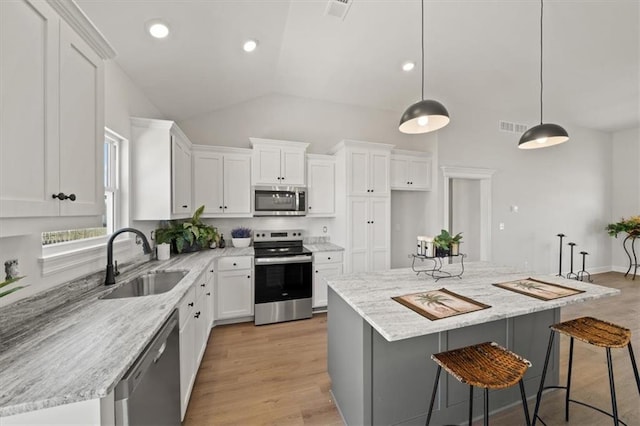 kitchen featuring stainless steel appliances, a sink, visible vents, white cabinets, and light wood-type flooring