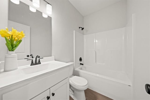 bathroom featuring wood finished floors, shower / bathing tub combination, vanity, and toilet