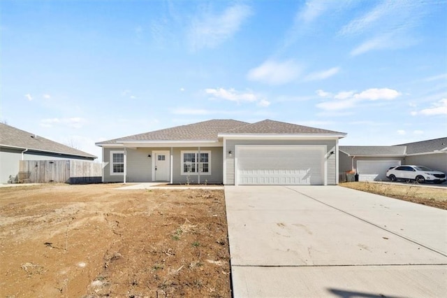 single story home with concrete driveway, an attached garage, and fence