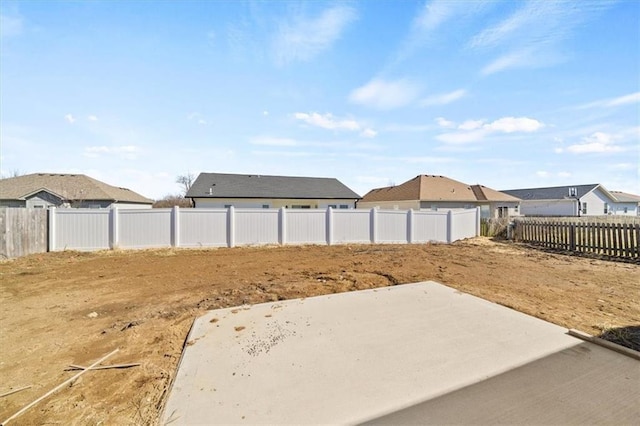 view of yard featuring a patio, a fenced backyard, and a residential view