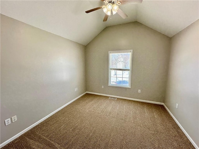 empty room featuring a ceiling fan, carpet flooring, vaulted ceiling, and baseboards