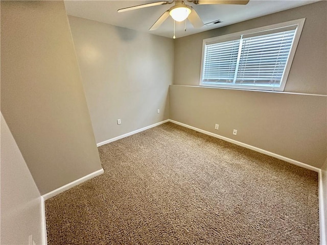 unfurnished room with carpet floors, visible vents, baseboards, and a ceiling fan