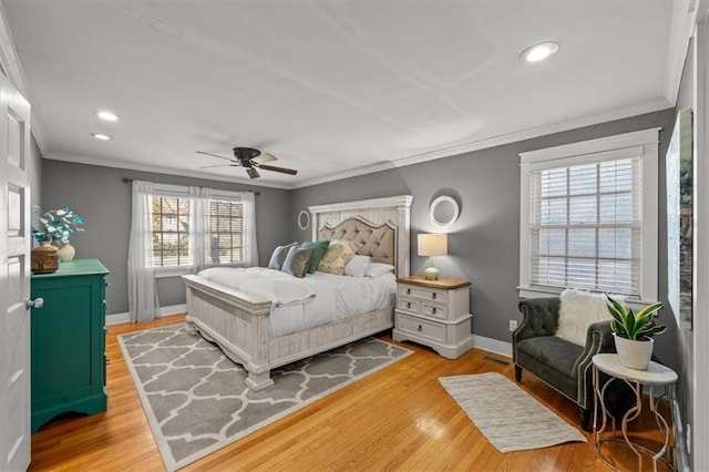 bedroom featuring baseboards, crown molding, and light wood finished floors