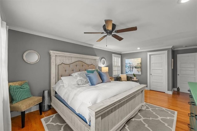 bedroom featuring light wood-style floors, crown molding, baseboards, and a ceiling fan